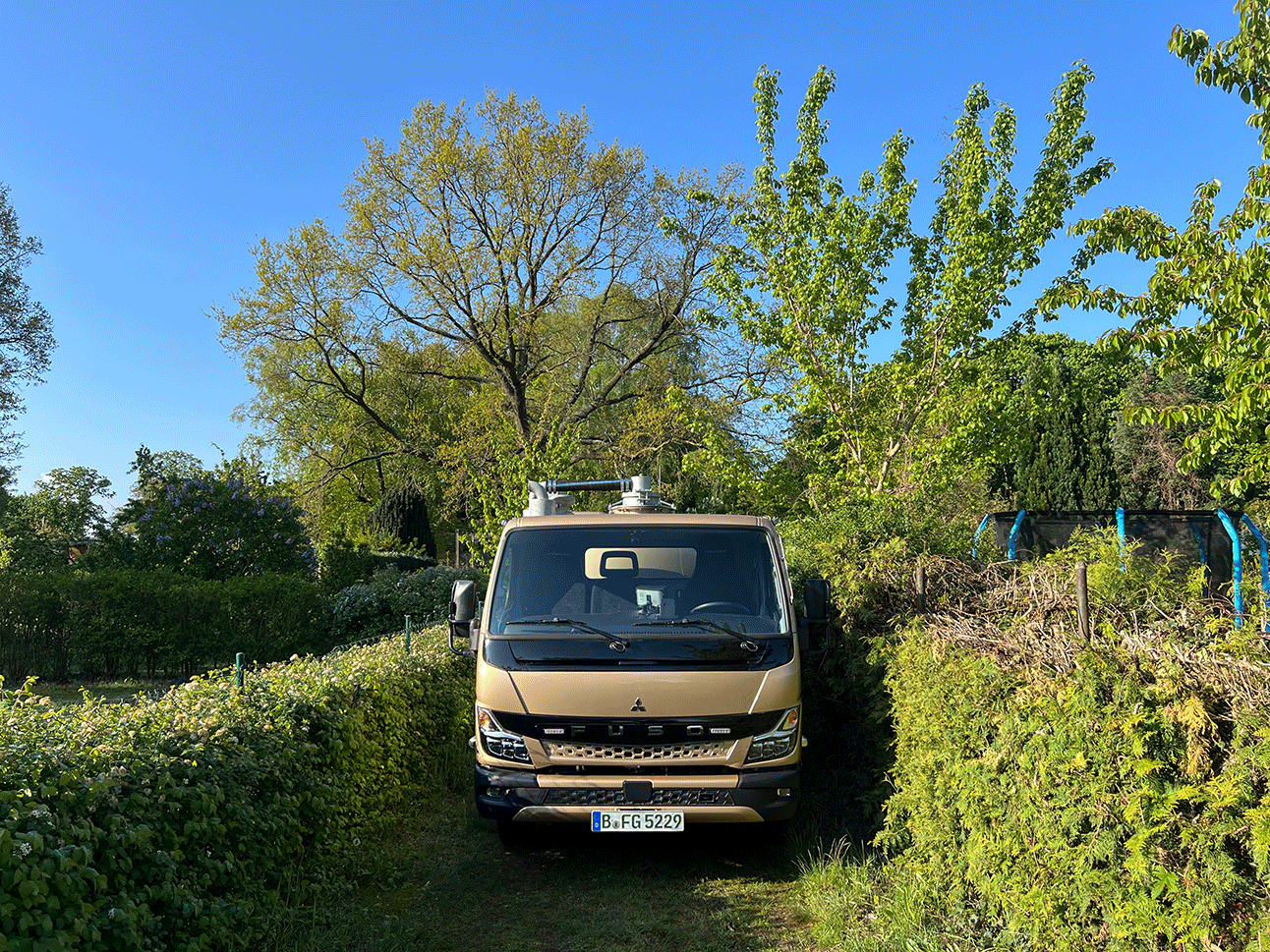 Ansicht kleiner Saugwagen auf schmalem Weg Gartensparte